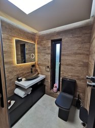 Koupelna s obklady v imitaci dřeva Noon a dlažbou v dekoru betonu Clay