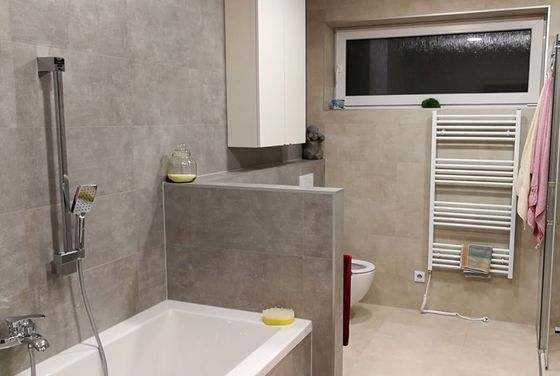 Dlažba a obklad Concrete v koupelně zákazníka. | Zákazníci mají ve svých koupelnách také velkoformátové obklady v imitaci betonu či kovu