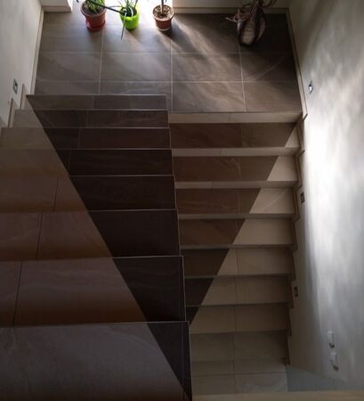 Dlažba imitující kámen Hills na schodišti zákazníka vypadá při pohledu shora jako trojúhelník. | Dlažba v imitaci horských kamenů se stala ozdobou netradičně řešeného schodiště