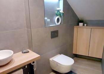 Stylovou podkrovní koupelnu má zákazník i díky dlažbě v imitaci betonu a řadě působivých detailů