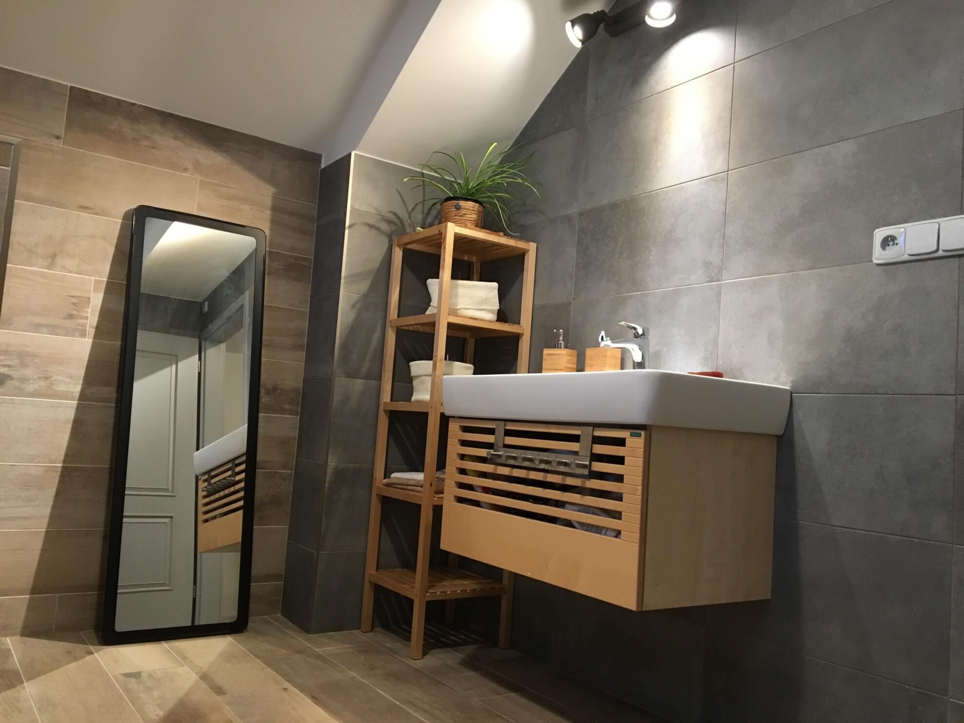 šedé obklady imitující cement s dlažbou imitující dřevo v koupelně