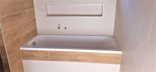 Světlá koupelna s kombinací bílého obkladu MEDLEY a dřeva NAU