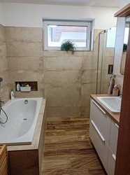 Koupelna s vanou a obklady v imitaci kamene + dlažbou v dekoru dřeva