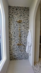 Designové lesklé obklady a dlažba Versace se zlatou baterií ve sprchovém koutu - inspirace z veletrhu Cersaie 2023