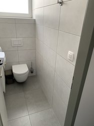 Toaleta s keramickým obkladem Inca white a dlažbou v imitaci betonu