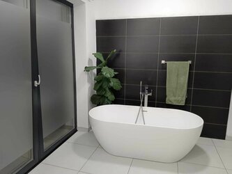 Černobílá koupelna s volně stojící vanou- černé obklady Rako + světlá dlažba Brush