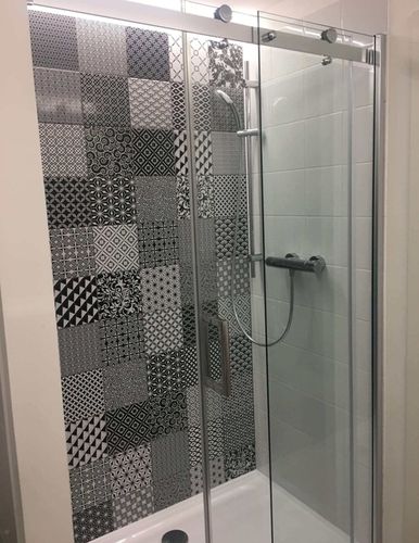 Ve sprchovém koutě se sprchovou vaničkou a elegantními pojezdy je položen obklad Moving.