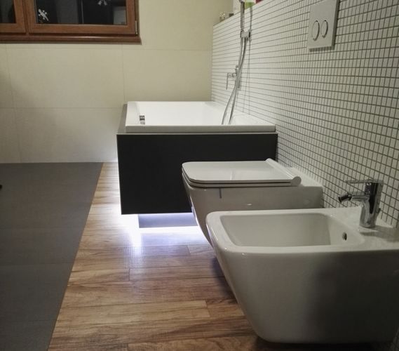 Prostor s bidetem, klozetem a vanou od zbytku koupelny opticky odděluje keramická dlažba v imitaci dřeva.