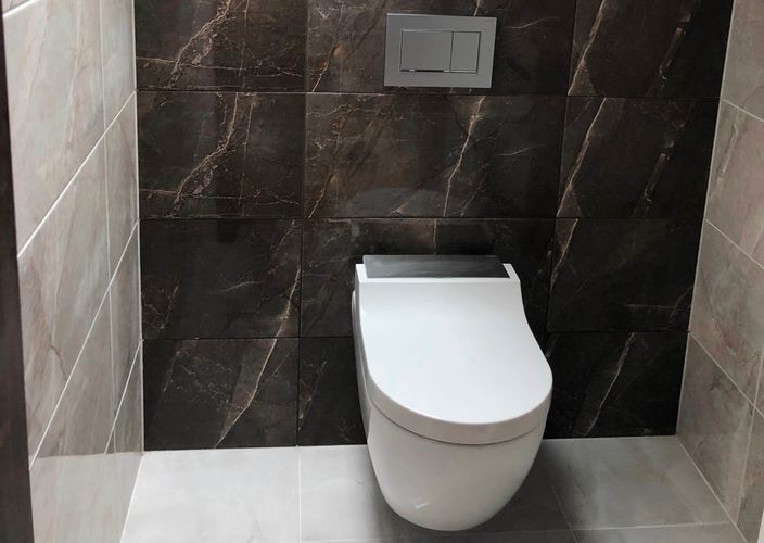 Elegantní závěsné WC v kombinaci s obkladačkami do koupelny a dlažbou Arch v imitaci mramoru.