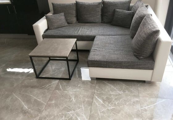 Detail slinuté dlažby imitující mramor Selection v obývacím pokoji zákazníka. | Dlažba v imitaci mramoru s lesklým povrchem se stala hvězdou obývacího pokoje propojeného s kuchyní