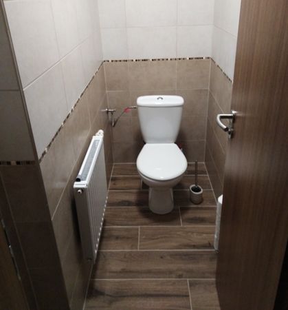 Dlažba imitující dřevo Clorofilla je položena také na toaletě zákazníka doplněné i zdobným páskem z mozaiky.   | Když dlažba v imitaci dřeva působí v koupelně našeho zákazníka nadčasově