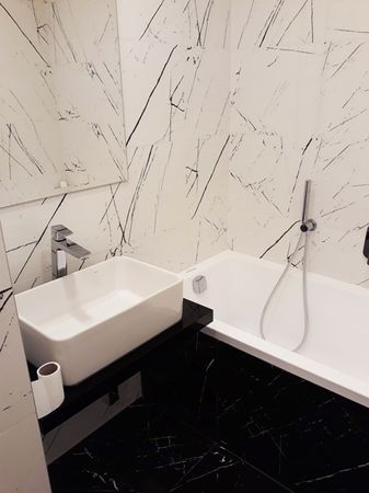 Velkoformátová dlažba a obklad Agatha v designu mramoru a rozměru 40×120 cm v koupelně. | Příklad malé koupelny s velkoformátovými obklady a dlažbou jednoho z našich zákazníků