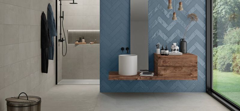 Koupelna s šedou dlažbou a obkladem Brush | Zajímavost dlažby Brush zvyšují velkoplošné dekorace s květinovými či geometrickými vzory
