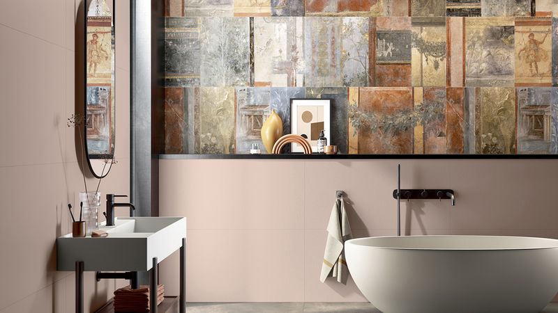 Růžové obklady Gioia v kombinaci celoplošným dekorem na stěně koupelny, který vypadá jako malovaný obraz | Některé keramické dekory z kolekce Gioia vypadají dokonce jako obraz od malíře