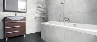 Koupelna s obklady a dlažbou v šedých barvách Grigio a Nero