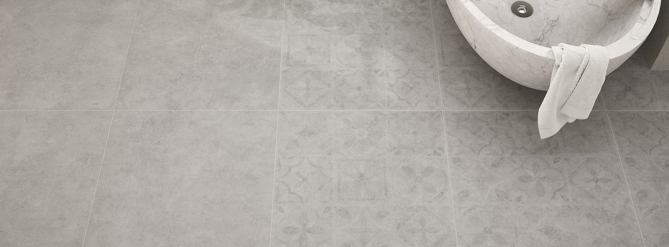 Šedá dlažba imitující cement Brera Cemento v koupelně včetně patchwork dekoru