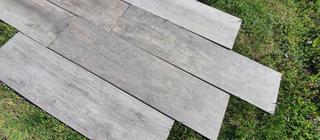 Venkovní dlažba Noon Ember šedá barva, dlažba položená na trávě pro posouzení barevnosti.